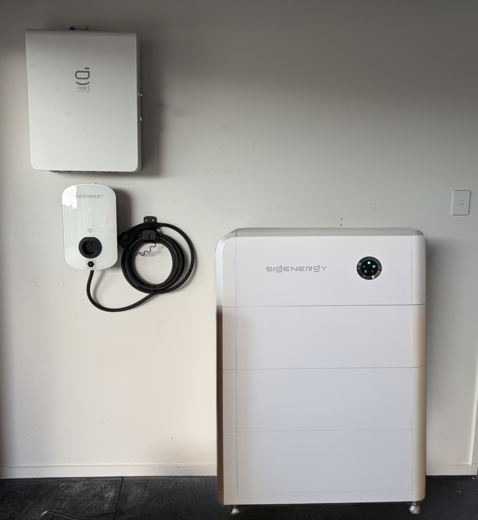 Sigenergy SigenStor white stacked home battery with wall-mounted Sigenergy EV charger and gateway in a garage